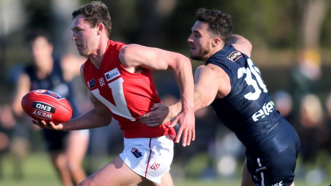 North Adelaide’s Will Combe breaks away from South Ãdelaide’s Nic Schwarz at Noarlunga Oval. Picture: Dean Martin.