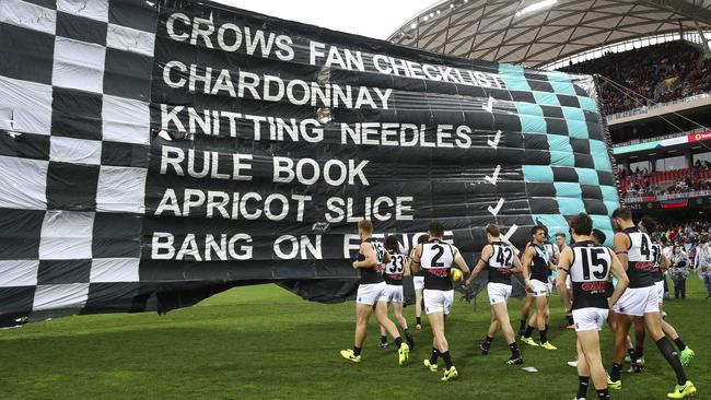 Port Adelaide run through their very cheeky banner. Picture: Sarah Reed