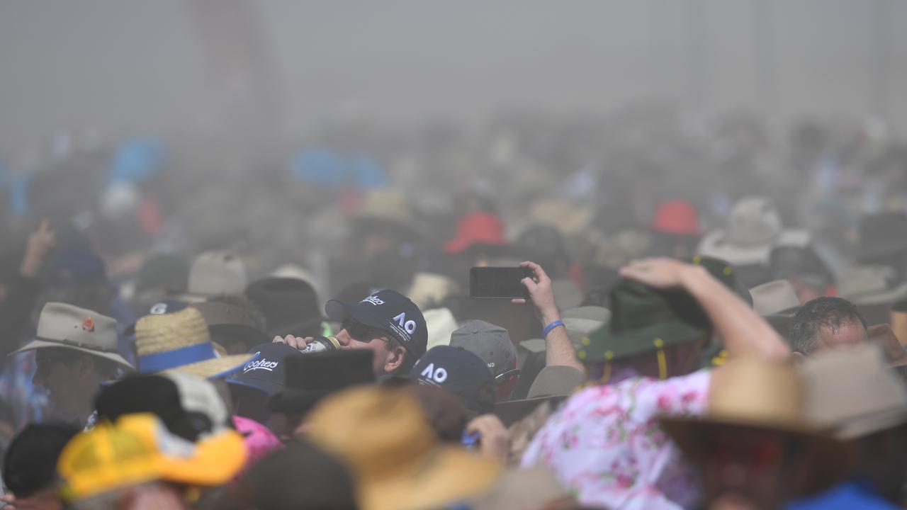 Crowds are shrouded in dust at the Birdsville Races in Birdsville as 50km wind gusts sweep through the track. Picture: AAP Image/Dan Peled.