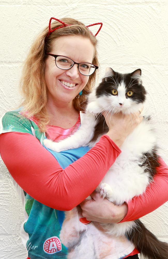 Nicole shows off Delilah who is available for adoption from the Cat Cuddle Cafe in Lutwyche. Picture: AAP/Sarah Marshall 