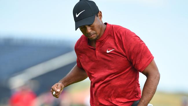 US golfer Tiger Woods reacts after holing his birdie putt on the 14th green.