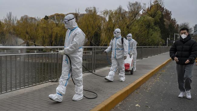 Epidemic control workers disinfect an area on the Liangma River, a popular area for local residents and the site of a protest against Covid measures. Picture: Getty Images