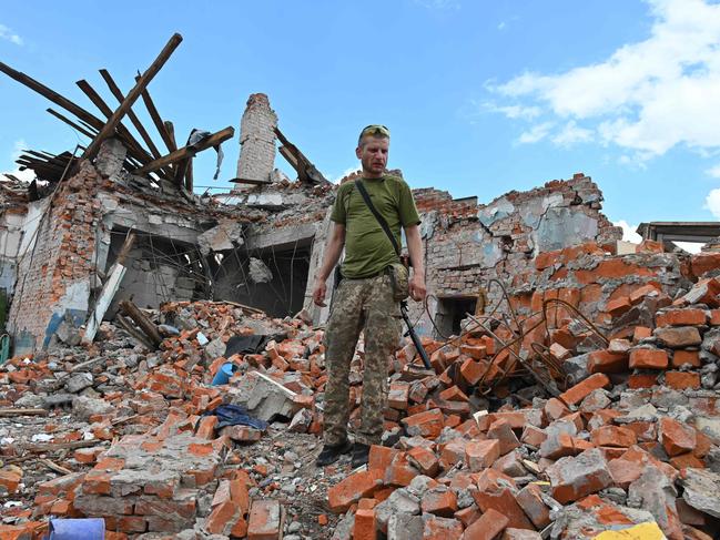 A Ukrainian serviceman inspects the ruins of Lyceum building, suspected to have been destroyed after a missile strike near Kharkiv on July 5, 2022, amid the Russian invasion of Ukraine. (Photo by SERGEY BOBOK / AFP)