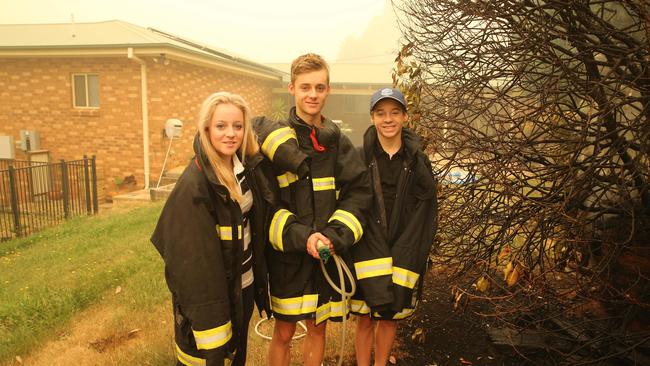 The Gould siblings stand at the point where the fire reached on Saturday night. Picture: Rohan Kelly