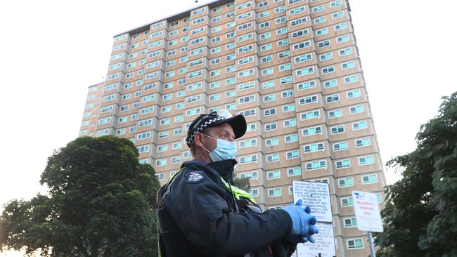 Police guard one of the Melbourne towers in lockdown. Picture: David Crosling