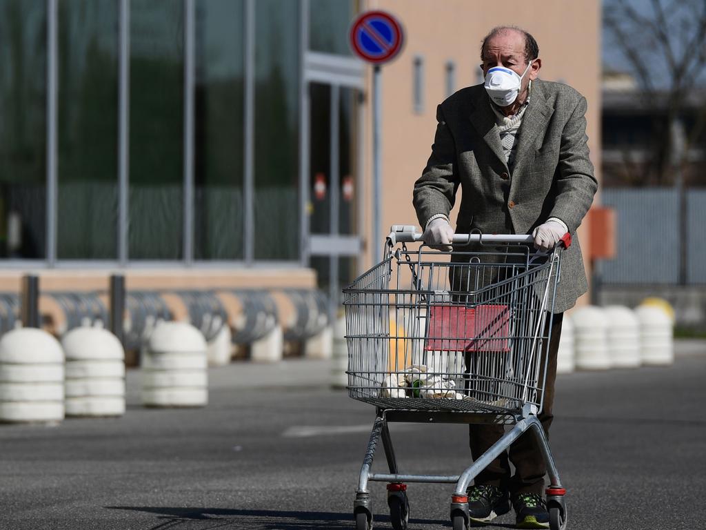 An elderly man wearing a protective mask pushes his cart as he arrives to shop at a supermarket in Codogno, southeast of Milan. Picture: Miguel MEDINA / AFP.