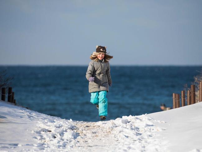 A young girl runs along a snowy beach as the temperature plummeted to -10 Celsius on the Baltic sea front in the north eastern town of Warnemunde, Germany, on February 28, 2018. A few walkers braved the wind and cold as countries across Europe shut schools and rushed to shelter homeless people on February 28, as a deadly blast of Siberian weather dubbed the “Beast from the East” kept the mercury far below zero. Picture: AFP