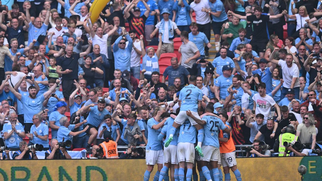 Ilkay Gundogan celebrates with teammates after scoring their second goal. Photo by Glyn KIRK / AFP.