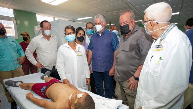 Cuban President Miguel Diaz-Canel (C) visits a child wounded during the explosion.