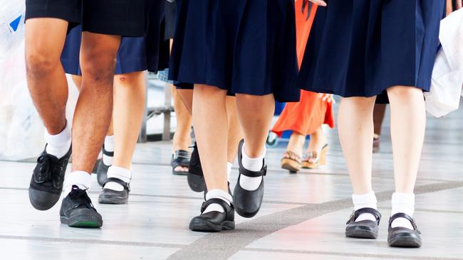 Capture of feet and shoes of students in school uniform and leaving shopping mall and walking over pedestrian bridge.