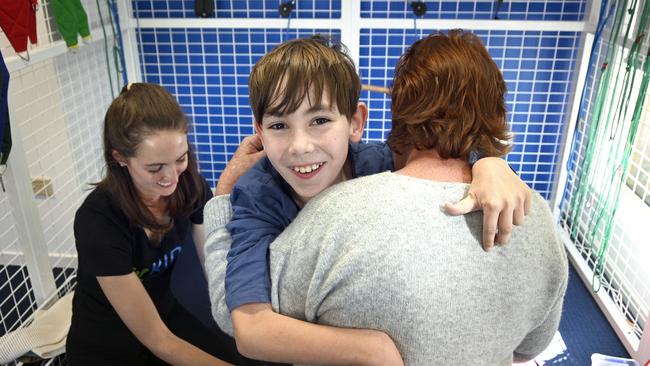 Angus Hopkins, from Nobby gives his mother, Jody Ezzy a hug while working with Belinda Bell from Toowoomba Kids Physiotherapy. In 2019, Angus finally received a wheelchair through NDIS after months of haggling, his wheelcair finally was supplied thanks to stories in The Chronicle. Twelve months on, Angus is mobile and able to to take part in a variety of activities. Photo Bev Lacey