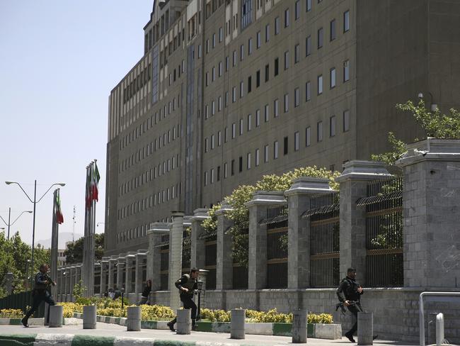 Police officers run to take position around Iran's parliament building after an assault of several attackers, in Tehran, Iran. Picture: Fars News Agency, Ali Khara via AP