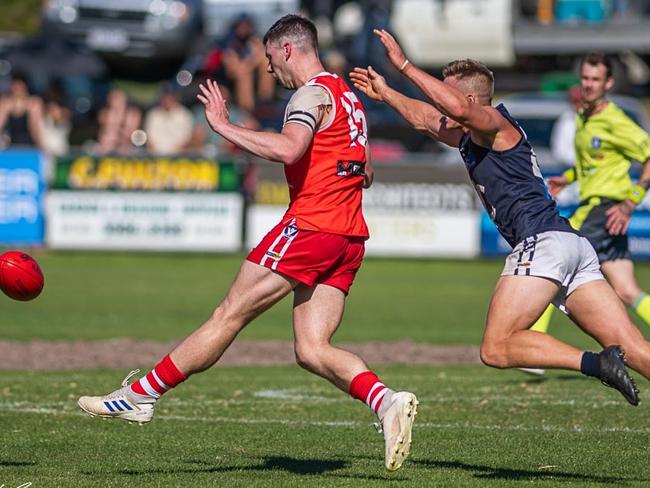 Sorrento recruit Jakob Steinhart gets his kick away ahead of Rosebud’s Sean Downie. Picture: David Caspar