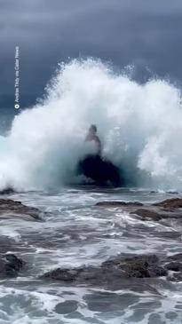 Man posing hit with a huge wave