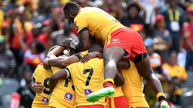 David Mead is congratulated by PNG teammates after scoring a try against Wales.