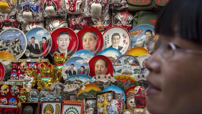 BEIJING, CHINA - AUGUST 28: A Chinese shopkeeper sells items including plates showing Chairman Mao and current president Xi Jinping and others at her stall in a market at a shopping district on August 28, 2015 in Beijing, China. China's government is relying on domestic consumption and services to sustain economic growth amid a slowdown in manufacturing and exports. Concerns about cracks in the world's second largest economy triggered a dramatic sell-off on global stock markets. China's government intervened to stop the rout by pumping billons of dollars in liquidity into its markets, cracking down on institutional selling and cutting interest rates for the fifth time in less than a year.  (Photo by Kevin Frayer/Getty Images)