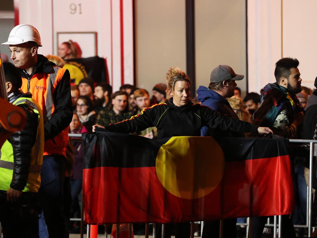 Nala Mansell holds the Indigenous flag at the Mike Parr performance art just before he enters the chamber under Macquarie Street, Hobart. Picture: NIKKI DAVIS-JONES