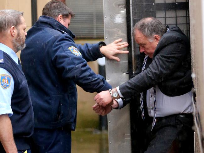 Glen McNamara is led out of a prison van at the King St Courts. Picture: John Grainger