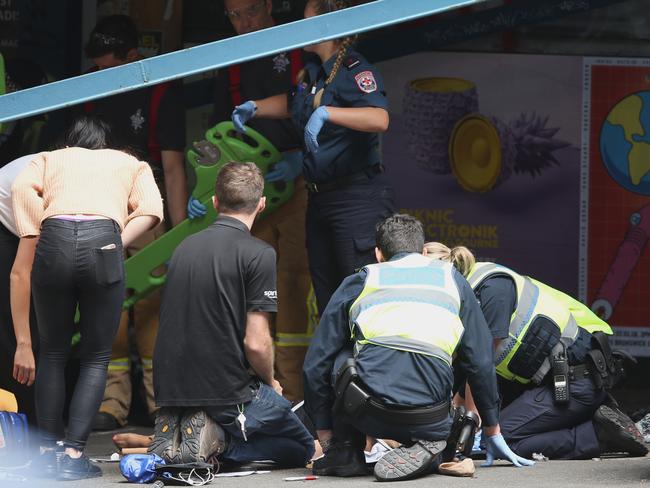 Police rush to the aid of a person struck down. Picture: David Crosling