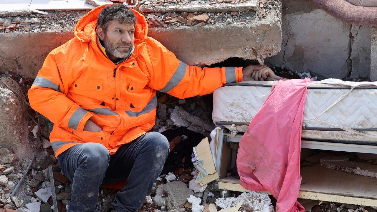 Mesut Hancer holds the hand of his 15-year-old daughter, Irmak, who died in the earthquake in Kahramanmaras, close to the quake's epicentre. Picture: Adem Altan/AFP