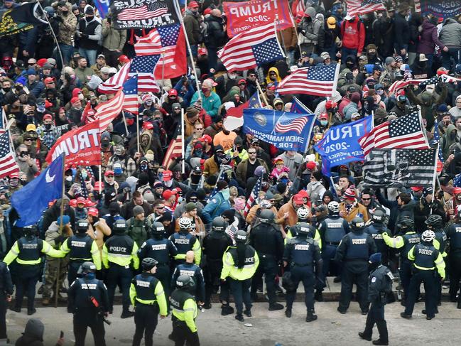 (FILES) In this file photo taken on January 06, 2021 Trump supporters clash with police and security forces as they storm the US Capitol in Washington, DC. - One year after supporters of Donald Trump stormed the US Capitol and shut down Congress, Americans still await a reckoning on the unprecedented challenge to the country's democracy. Was it a simple protest-turned-riot? An insurrection? A coup attempt plotted by Trump? Videos from January 6, 2021 bear witness to the violence wrought in the former president's name. Attackers beating security officers with iron bars and clubs. A policeman crushed in a doorway, howling in pain. Rioters clad in assault gear chanting "Hang Mike Pence," while the vice president and Democratic and Republican lawmakers flee. A woman shot to death in a Capitol hallway. Americans were stunned by the hours-long assault, and so was much of the world, accustomed to seeing the United States as a model of stable democracy. One year later, the brazen attempt to prevent Democrat Joe Biden from taking office after his victory in the November 2020 presidential election needs an accounting. (Photo by Olivier DOULIERY / AFP)