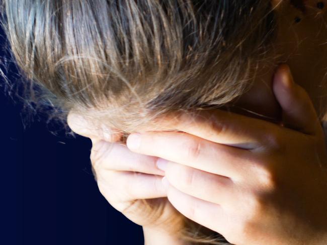 teenage girl holds her head in her hands because she is very desperate, ideal footage to represent problems of bullying and depression, bullying