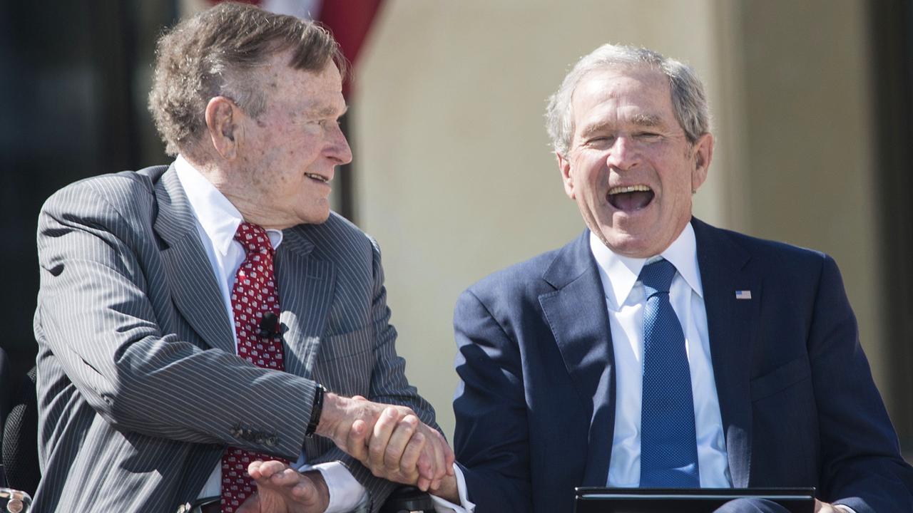April 2013: Former US President George H.W. Bush shakes hands with his son, former US President George W. Bush's, during a dedication ceremony at the George W. Bush Library and Museum. Picture: AFP