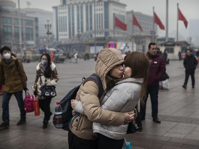 BEIJING, CHINA - JANUARY 26:  A Chinese couple kiss as they say goodbye to each other before traveling home at Beijing Railway Station on January 26, 2017 in Beijing, China. Millions of Chinese will travel home to visit families in what is often called the largest human migration during the Spring Festival holiday period that begins with the Lunar New Year on January 28, 2017.  (Photo by Kevin Frayer/Getty Images) *** BESTPIX ***