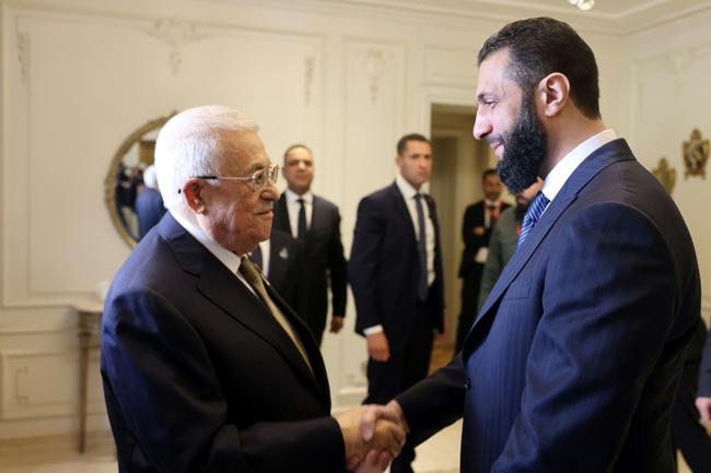 Palestinian president Mahmud Abbas (L) greets Syria's interim President Ahmed al-Sharaa in Cairo