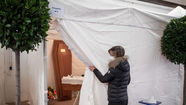 An employee of the 'Pompes Funebres Generales Geneve' (Geneva's General Funeral Pumps) shows a room with a coffin at a temporary funeral home made with tents, in Carouge near Geneva. Picture: AFP.