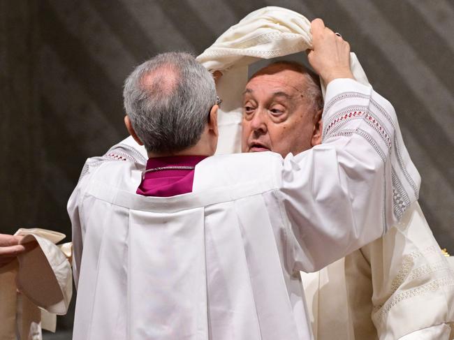 Pope Francis is helped to remove his ceremonial vestments at the end of the vespers at St Peter's basilica in The Vatican, on February 1, 2025. (Photo by Tiziana FABI / AFP)