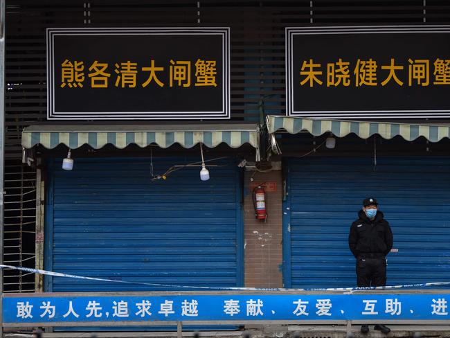 A security guard stands outside the Huanan Seafood Wholesale Market where the coronavirus was detected in Wuhan. Picture: AFP