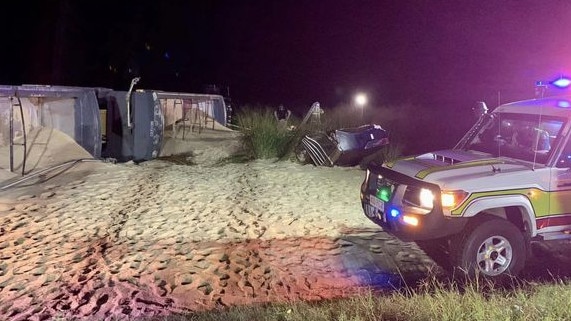 A sugar truck lies on its side with its contents spilt across the ground after a collision between a sedan and a truck on the Palmerston Highway near Innisfail left two men dead. Picture: QAS