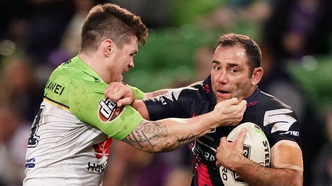 Cameron Smith of the Storm is tackled by John Bateman of the Raiders