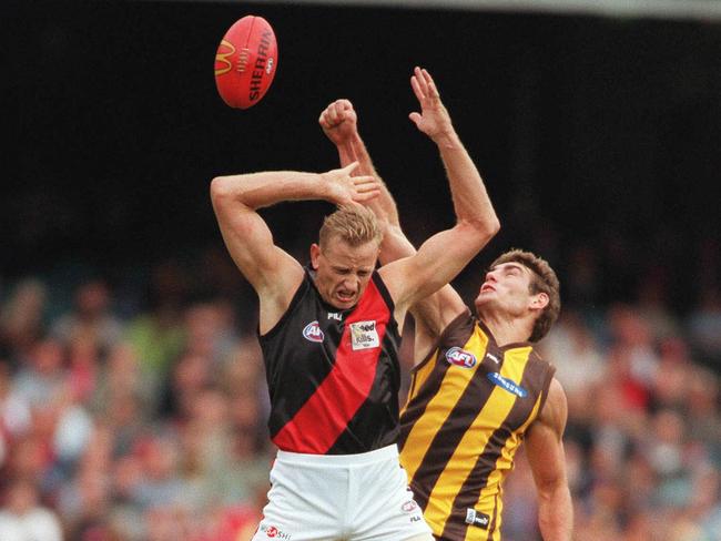 John Barnes clashes with Hawthorn’s Nick Holland. The former Essendon premiership player believes concussion has caused brain damage. Picture: News Corp