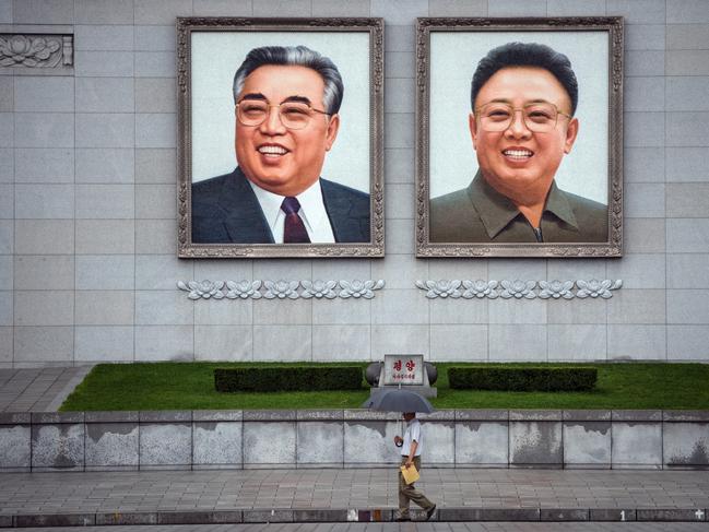 People walk beneath huge pictures of Kim Il-sung and Kim Jong-il in Pyongyang, North Korea. Picture: Getty Images