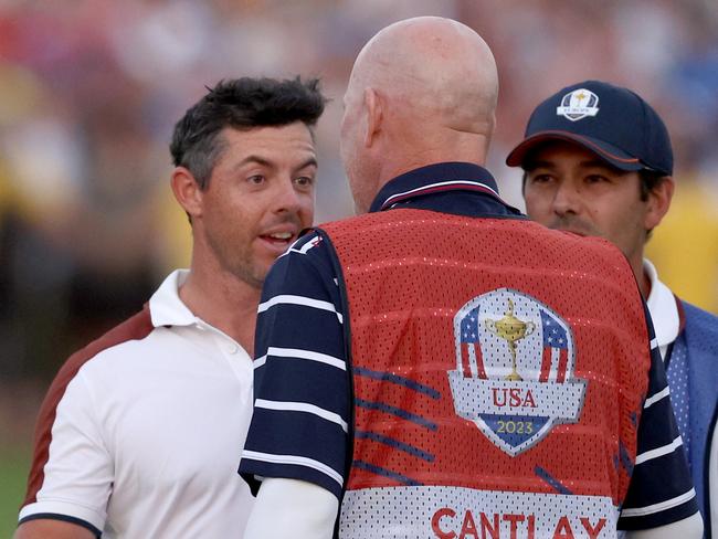 ROME, ITALY - SEPTEMBER 30: Rory McIlroy of Team Europe speaks with caddie of Patrick Cantlay of Team United States (not pictured), Joe LaCava on the 18th green during the Saturday afternoon fourball matches of the 2023 Ryder Cup at Marco Simone Golf Club on September 30, 2023 in Rome, Italy. (Photo by Patrick Smith/Getty Images)