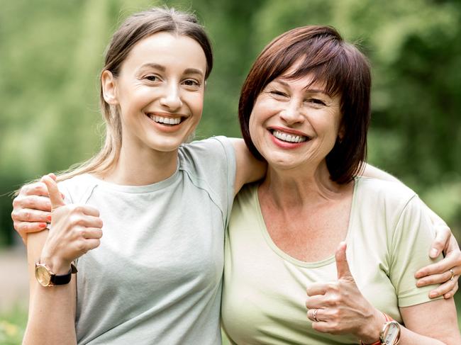 Portrait of a young and elder woman hugging together during the yoga exercise in the park