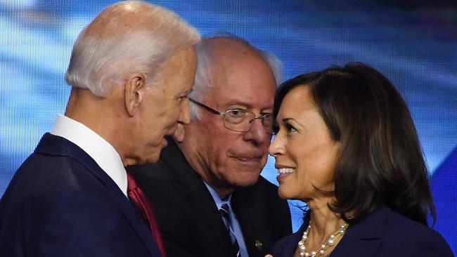 Joe Biden (L) and California Senator Kamala Harris (R) speak while Vermont Senator Bernie Sanders walks by after the third Democratic primary debate of the 2020 presidential campaign. Picture: AFP.