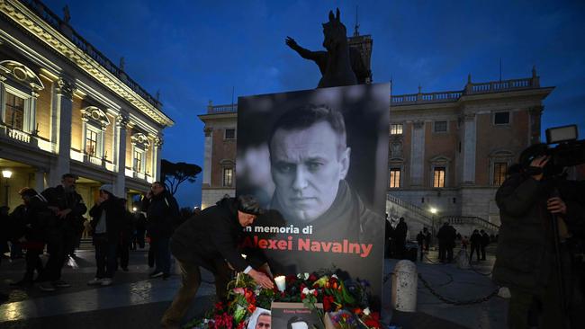 People bring flowers and candles for a vigil in honour of Alexei Navalny.