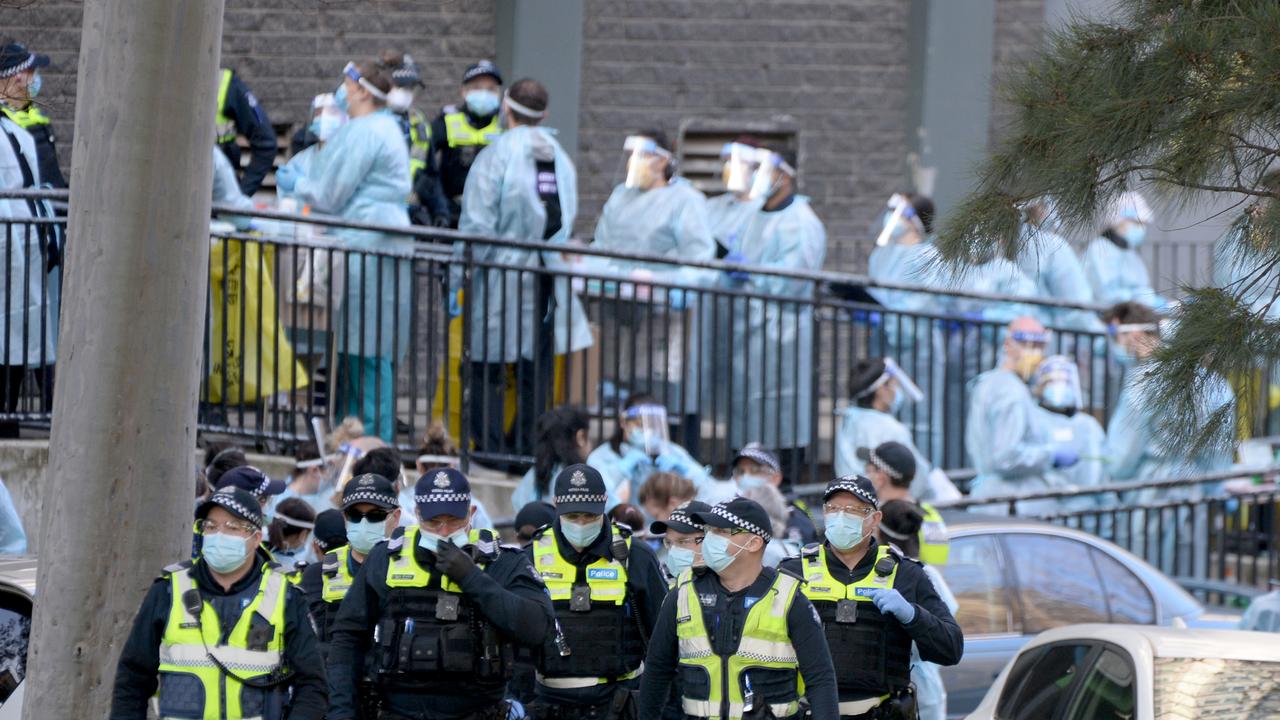 Police and healthcare workers as they prepare to enter one of the locked down towers at the North Melbourne public housing estate. Picture: NCA NewsWire/Andrew Henshaw