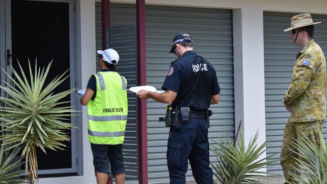 A Public Health environmental health officer, NT Police officer and an Australian Defence Force member check in on those self isolating to ensure they are following quarantine regulations. Picture: Will Zwar