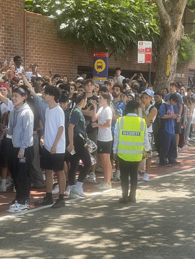 Security keeping the crowd off the road.