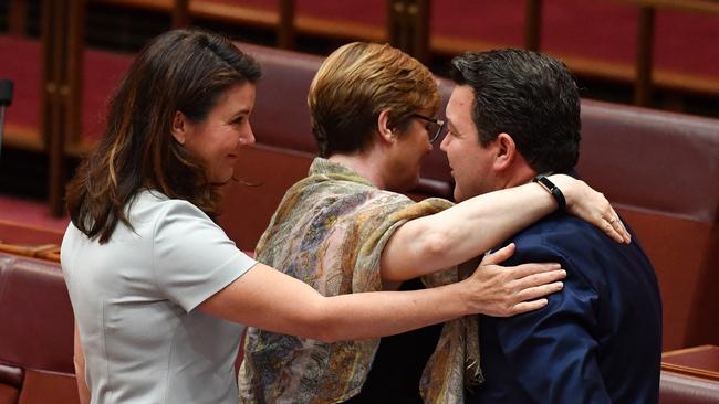 Liberal senators Jane Hume (L) and Linda Reynolds (C) hug Liberal Senator Dean Smith after he spoke on the Same Sex Marriage Bill debate in the Senate this week. (Pic: Mick Tsikas/AAP)