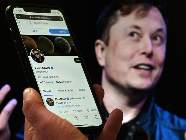 (FILES) In this file photo taken on April 14, 2022 a phone screen displays the Twitter account of Elon Musk with a photo of him shown in the background, in Washington, DC. - Twitter suspended December 15, 2022, the accounts of more than a half-dozen journalists who had been writing about the company and its new owner Elon Musk. Some of the journalists had been tweeting about Twitter shutting down an @ElonJet account that tracked flights of the billionaire's private jet and about versions of that account hosted at other social networks. (Photo by Olivier DOULIERY / AFP)