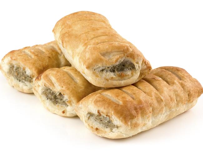 "Four sausage rolls on a white background. Main focus on the front of the top sausage roll, softer focus towards the immediate front and far back."