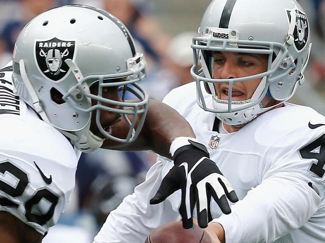 FOXBORO, MA - SEPTEMBER 21: Derek Carr #4 of the Oakland Raiders hands off to Darren McFadden #20 during the first quarter against the New England Patriots at Gillette Stadium on September 21, 2014 in Foxboro, Massachusetts. Jim Rogash/Getty Images/AFP == FOR NEWSPAPERS, INTERNET, TELCOS & TELEVISION USE ONLY ==