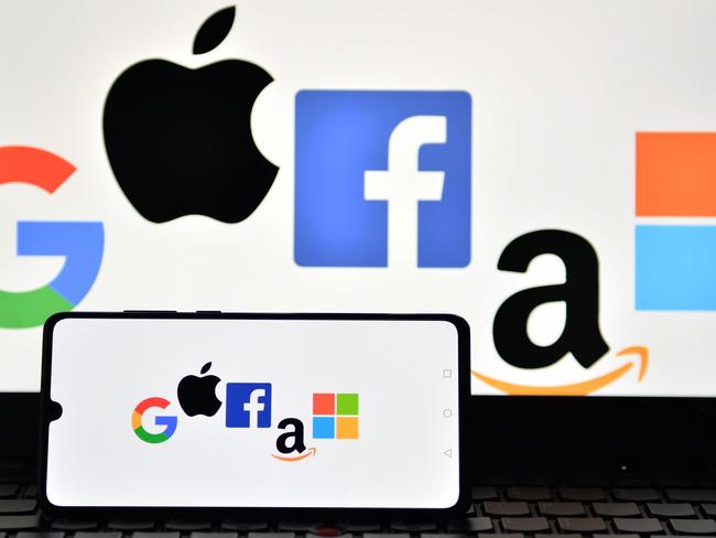 (FILES) This file photo illustration picture taken in London on December 18, 2020 shows the logos of Google, Apple, Facebook, Amazon and Microsoft displayed on a mobile phone and a laptop screen. - Google, Twitter and Amazon are hopeful that Joe Biden's incoming administration in the United States will enact a federal digital data law, senior company officials said at CES, the annual electronics and technology show. "I think the stars are better aligned than ever in the past," Keith Enright, Google's chief data privacy office, told a discussion January 12, 2021 on trust and privacy. (Photo by JUSTIN TALLIS / AFP)