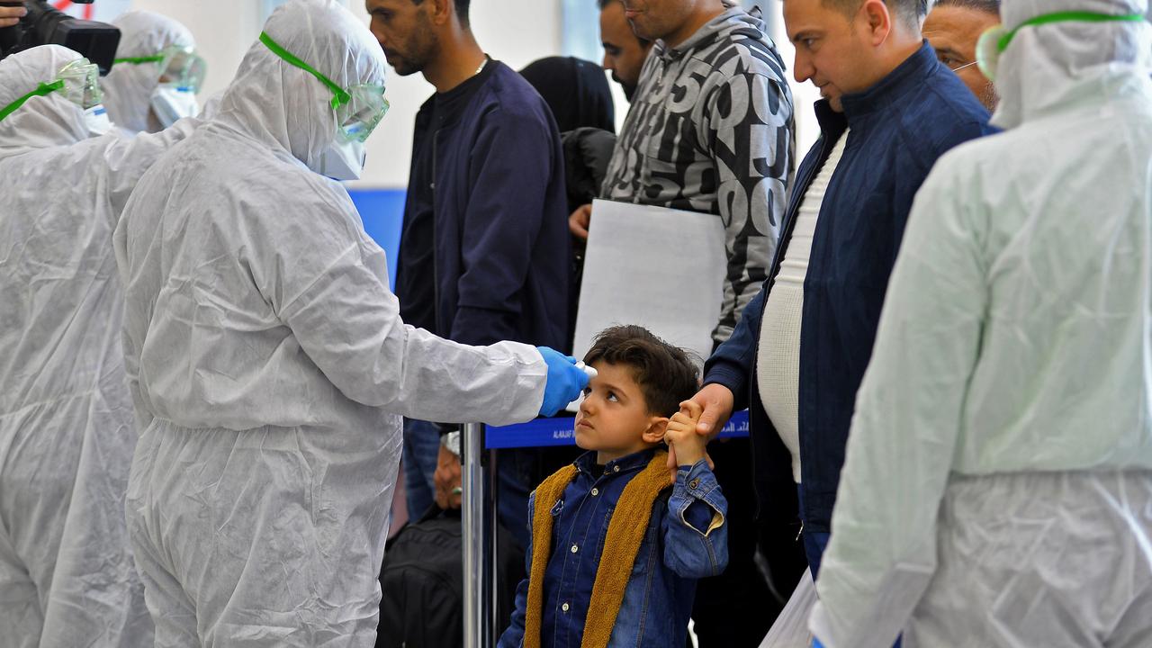 A child has their temperature taken at Najaf International Airport on February 21 after returning to Iraq from Iran. Picture: Haidar Hamdani/AFP