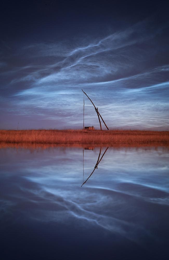 Noctilucent Night, Peter Hoszang. This image won highly commended in the Skyscapes category. Noctilucent clouds are a rare phenomenon that occur high up in the atmosphere and appear to glow with a silvery hue at night when illuminated by sunlight from below the horizon. Location: Hungary.